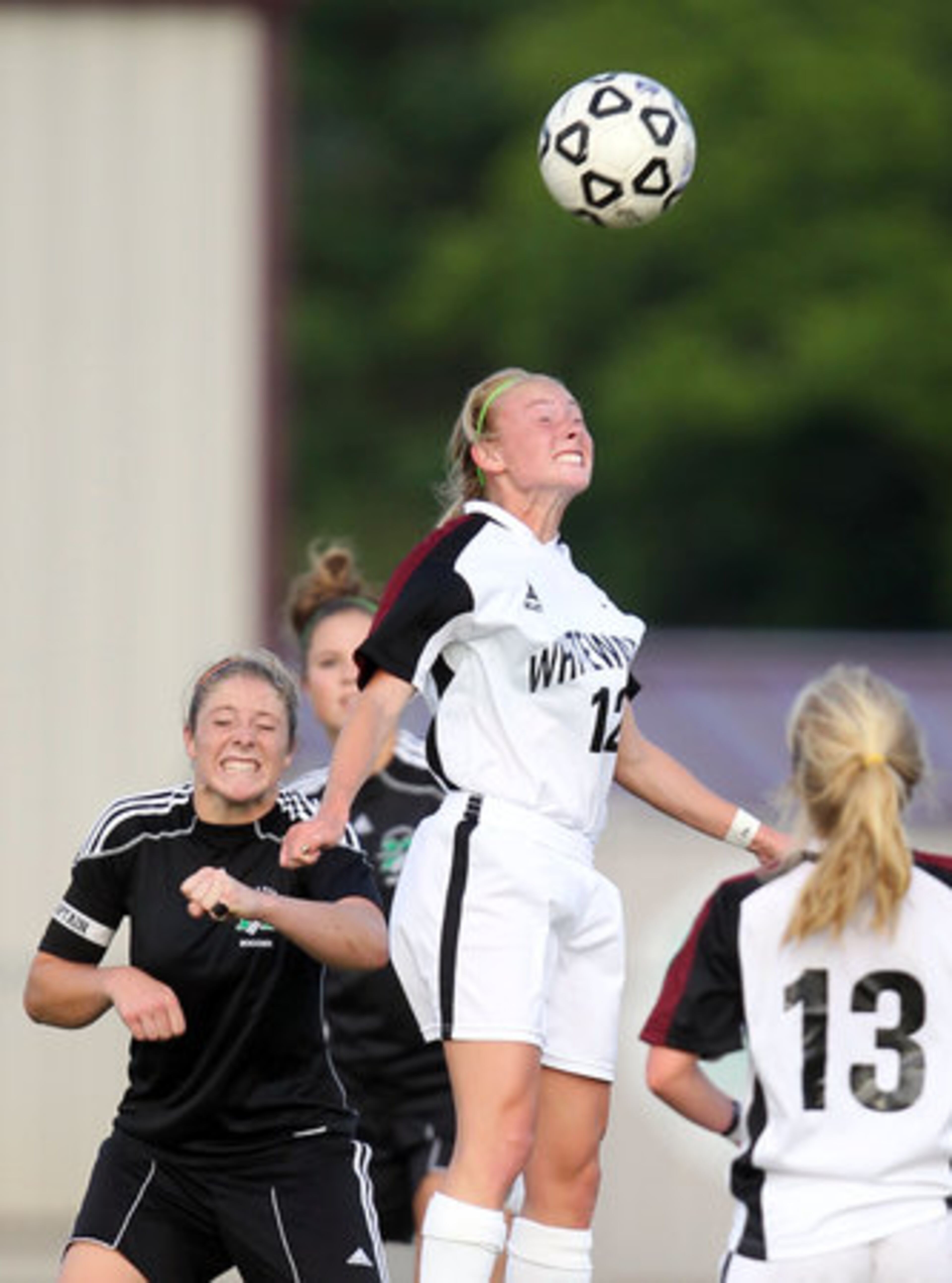 Whitewater's Taylor Marks (center) heads the ball against McIntosh's Danielle Gray, left, in the first half of their Class AAAA girls soccer state championship game at Whitewater High School Saturday afternoon in Fayetteville, Ga., May 19, 2012.