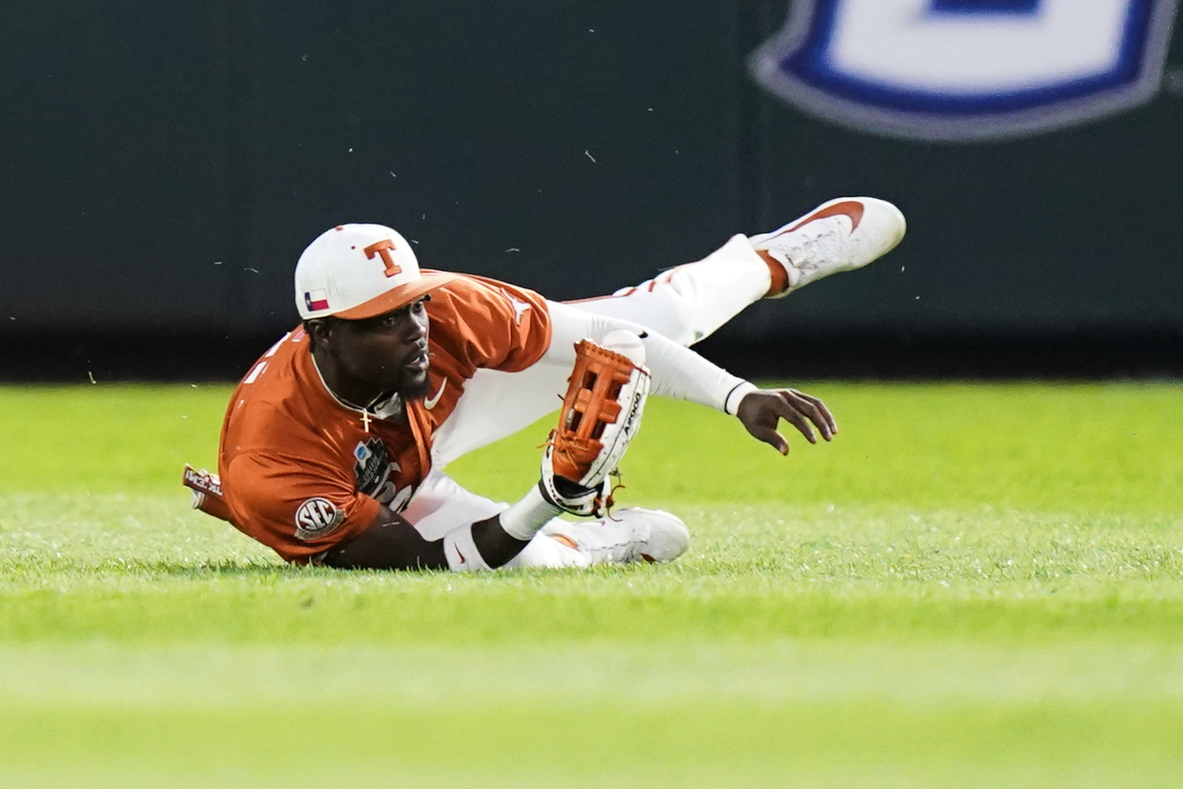 Texas outfielder Dariyan Pendergrass (42) catches the ball and then drops it during an NCAA baseball College World Series elimination game against Georgia, Tuesday, June 16, 2026 in Omaha, Neb. Georgia won 2-0. (AP Photo/Vera Nieuwenhuis)
