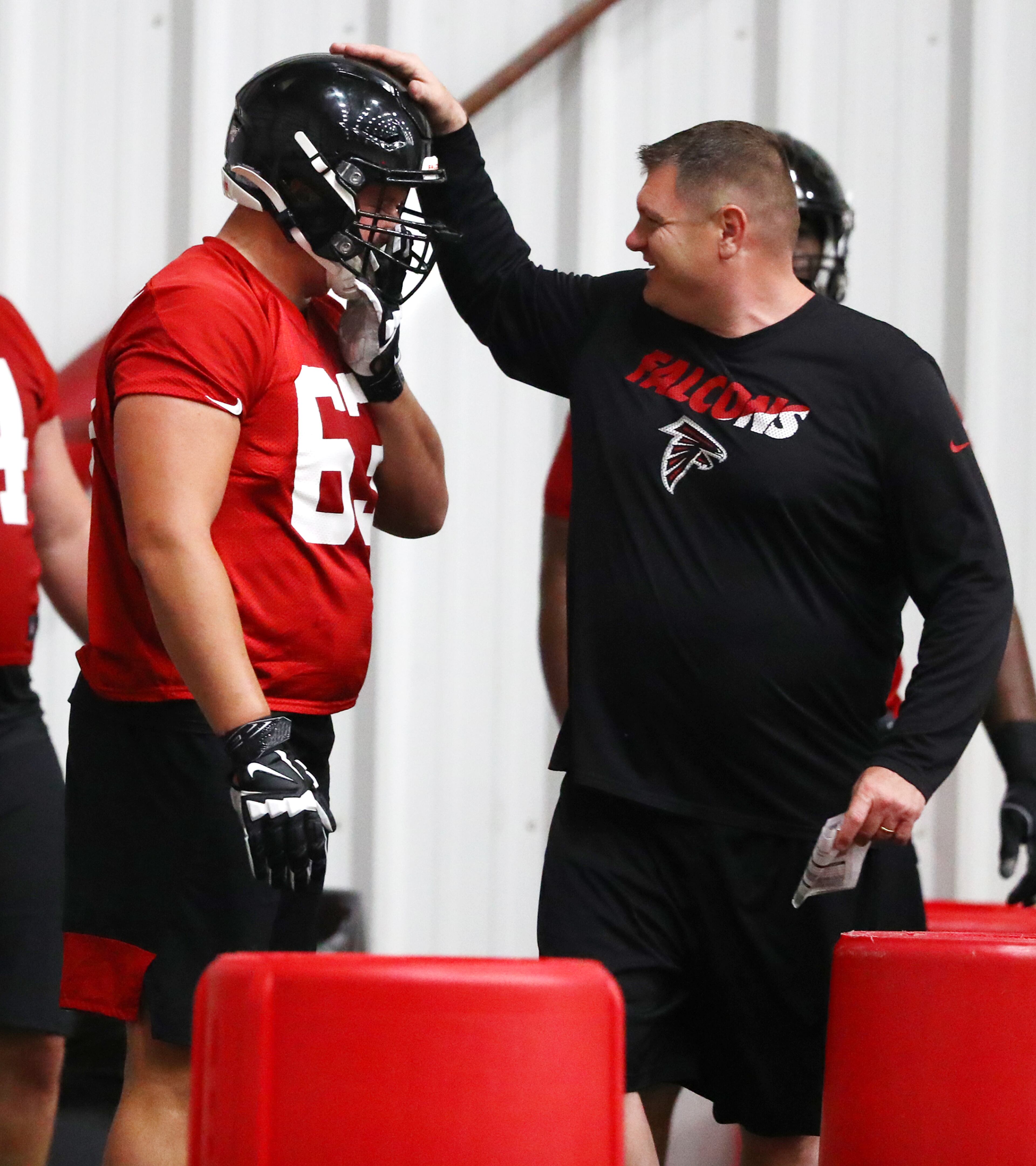 Falcons offensive line coach Chris Morgan gives first round draft pick Chris Landstrom a pat on the helmet after a blocking drill during rookie minicamp on Saturday, May 11, 2019, in Flowery Branch. Curtis Compton/ccompton@ajc.com
