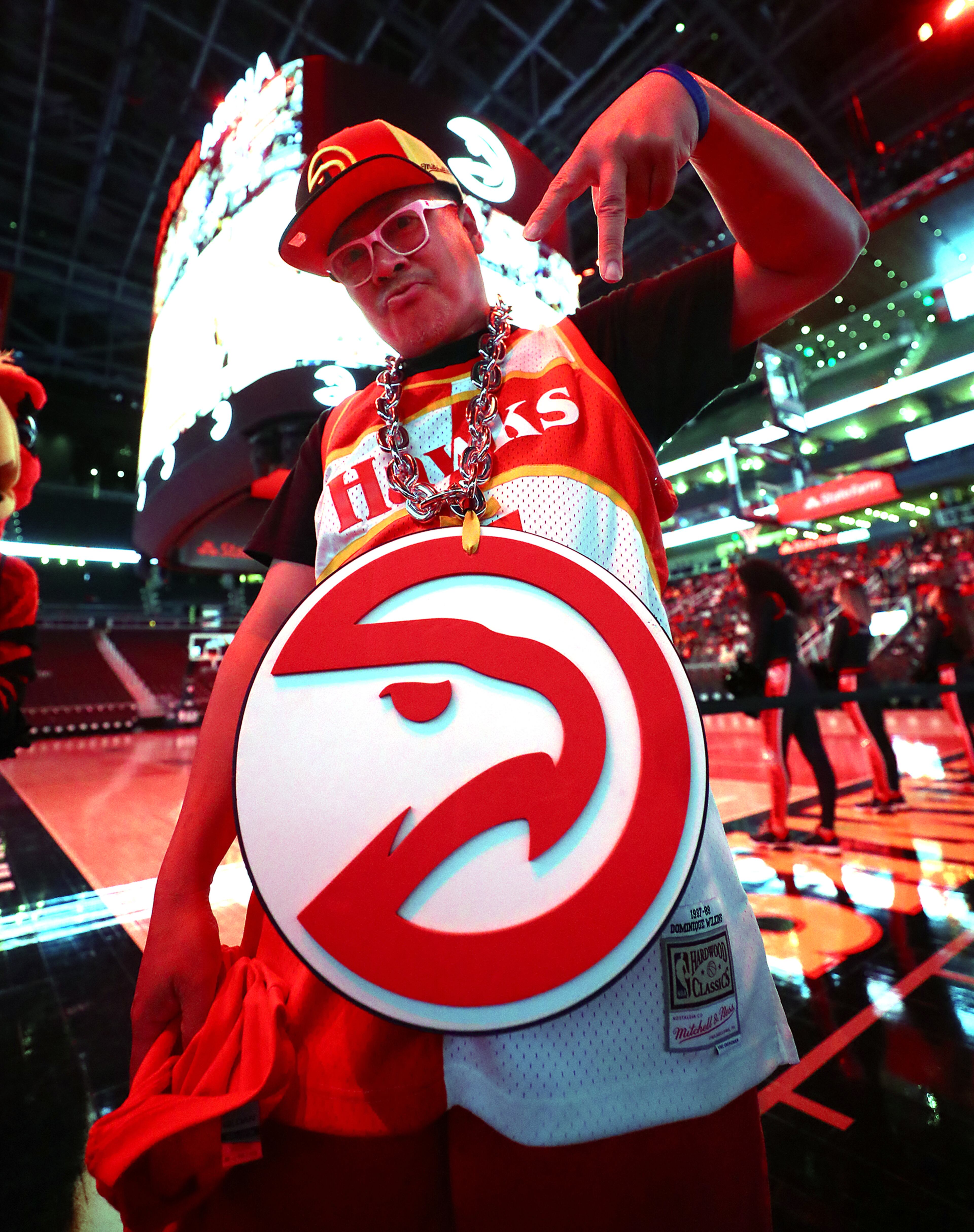 Rodney Barron, Marietta, sports his giant Hawks logo necklace while taking in the game. “Curtis Compton / Curtis.Compton@ajc.com”