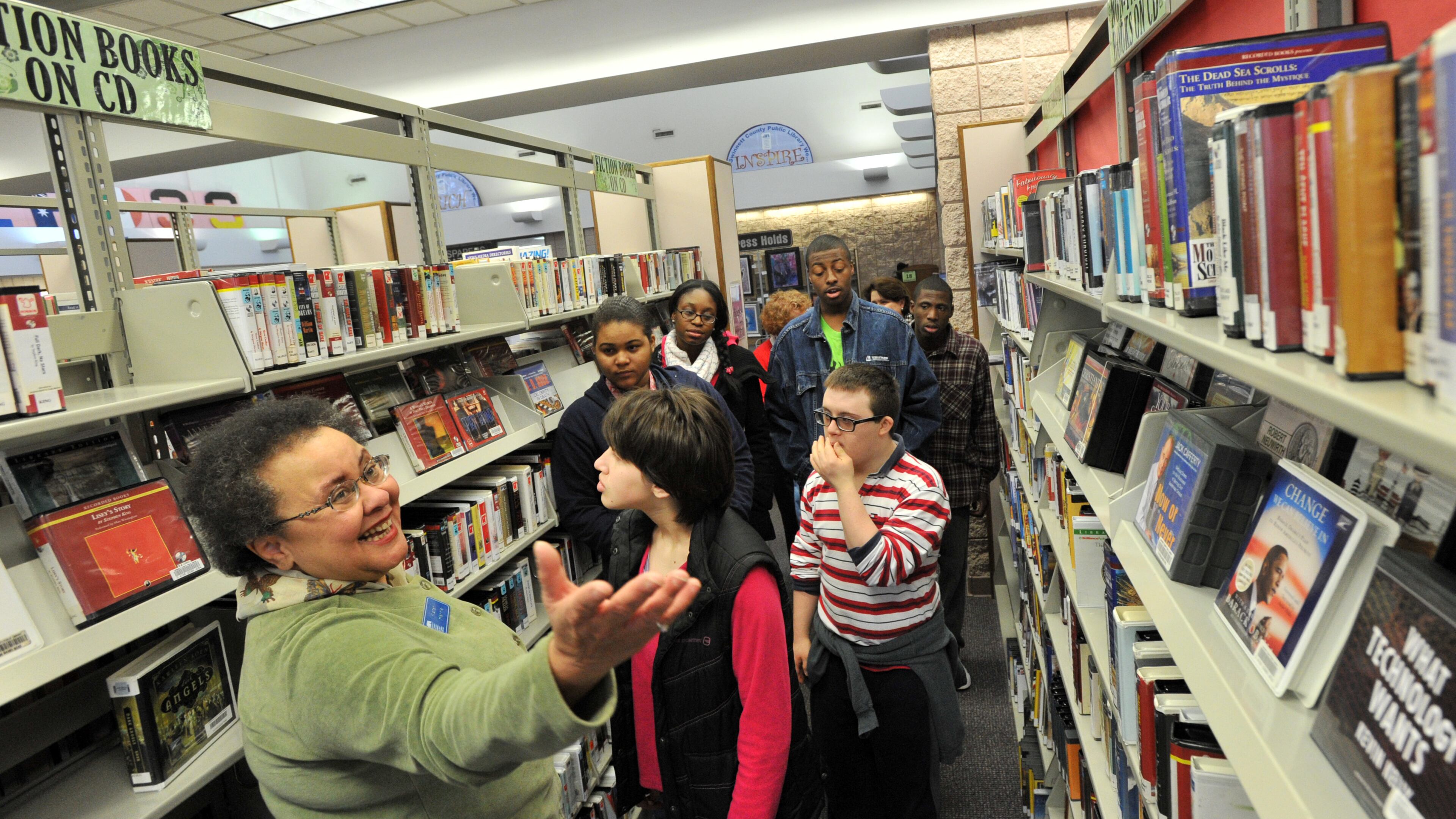 In this 2013 file photo, Karen Harris (left), manager of the Norcross branch of the Gwinnett Public Library System, leads a tour group.