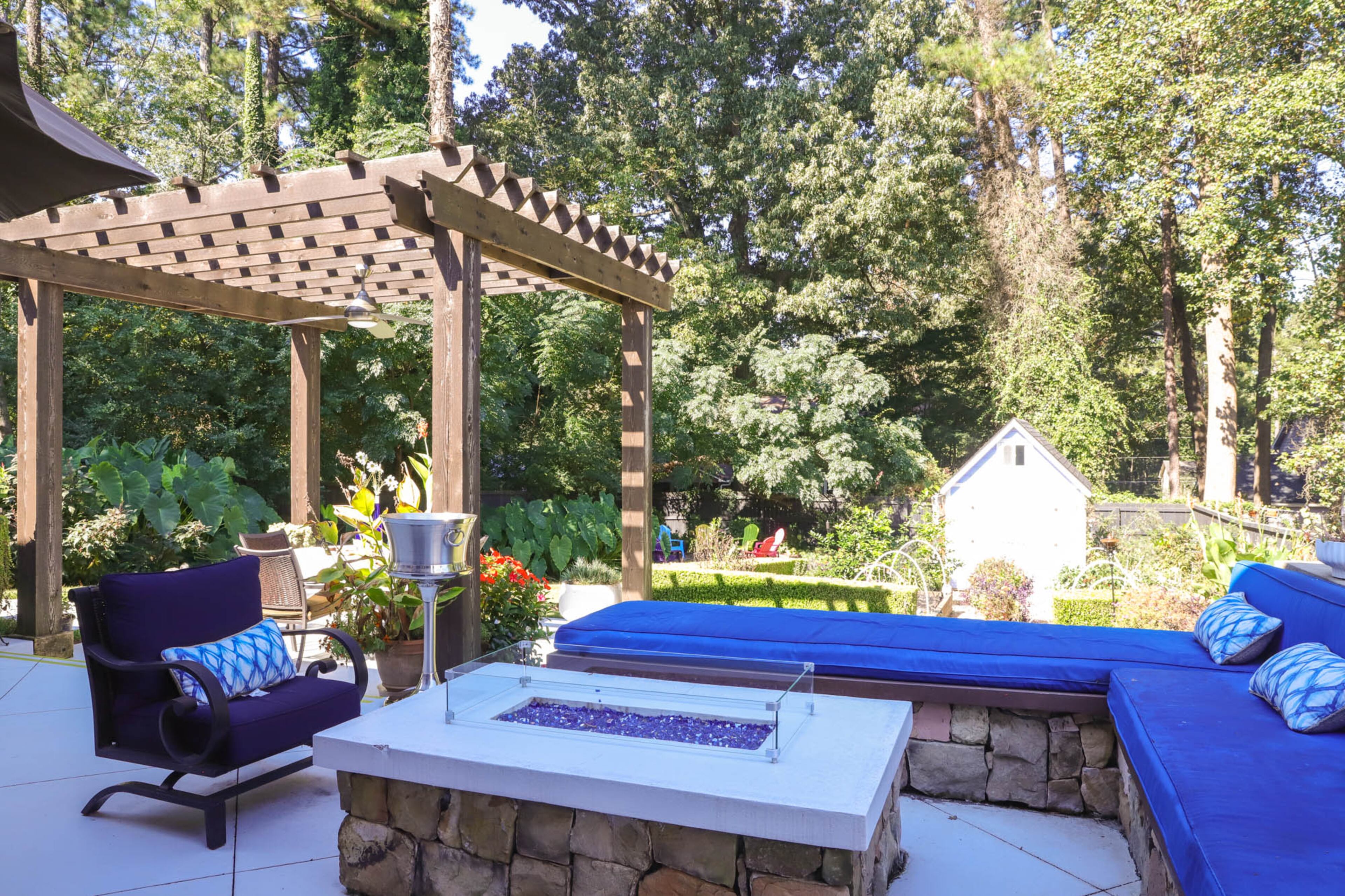 The first renovations that Liza Hare made to her 2000 home was to create an outdoor kitchen and living area in the backyard. Now the space consists of several destinations, each with its own draw. Liza designed the stone seating around the gas firepit and made the wooden bench herself, topping it with cushions. Text by Shannon Dominy/Photo by Reynolds Rogers