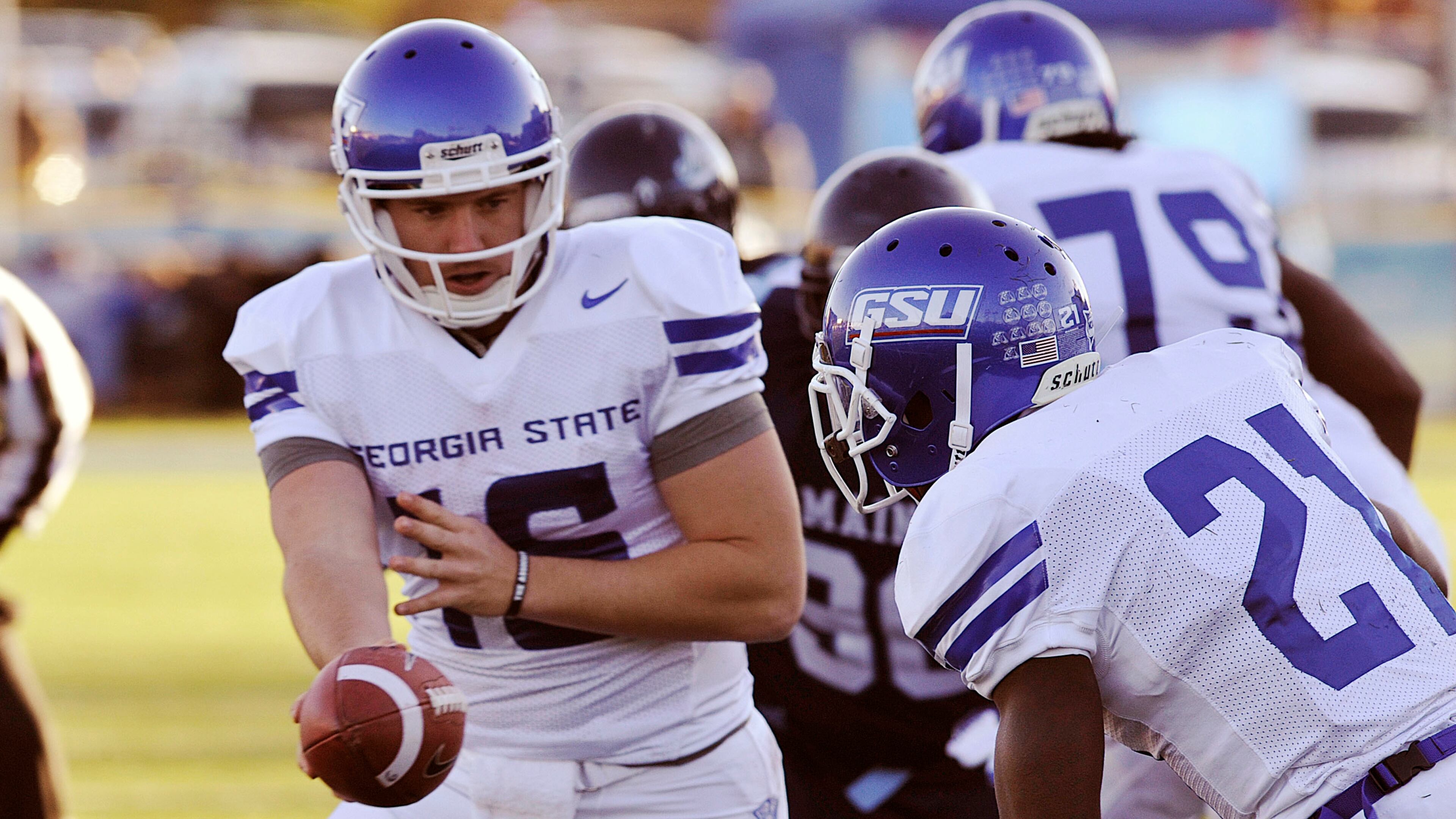 Panthers QB Ben McLane hands off to Travis Evans during first half action.