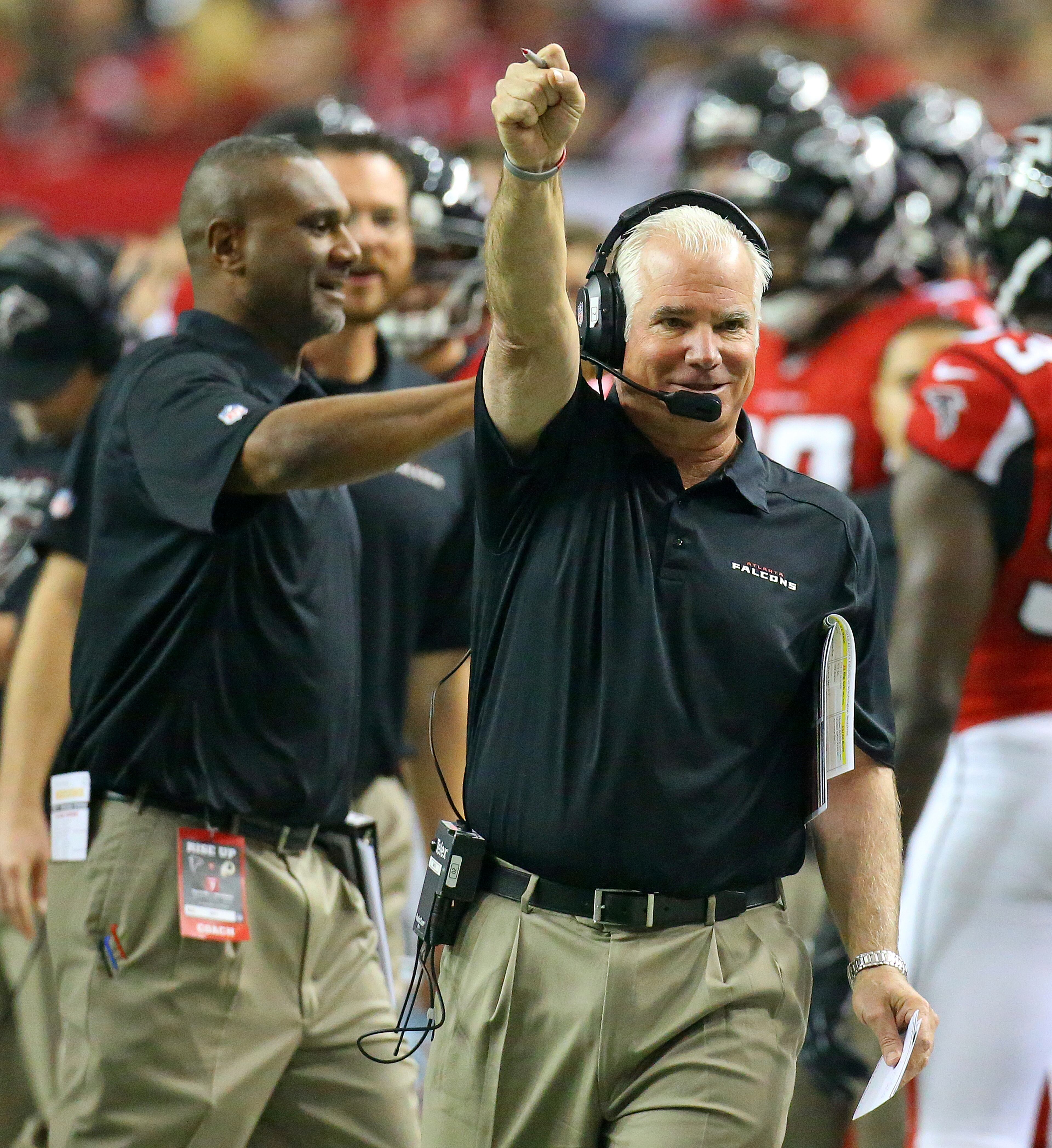 Falcons head coach Mike Smith pumps his fist celebrating as Falcons cornerback Robert McClain recovers a Redskins fumble on a kickoff return during 1st half action in a NFL football game on Sunday, Dec. 15, 2013, in Atlanta.