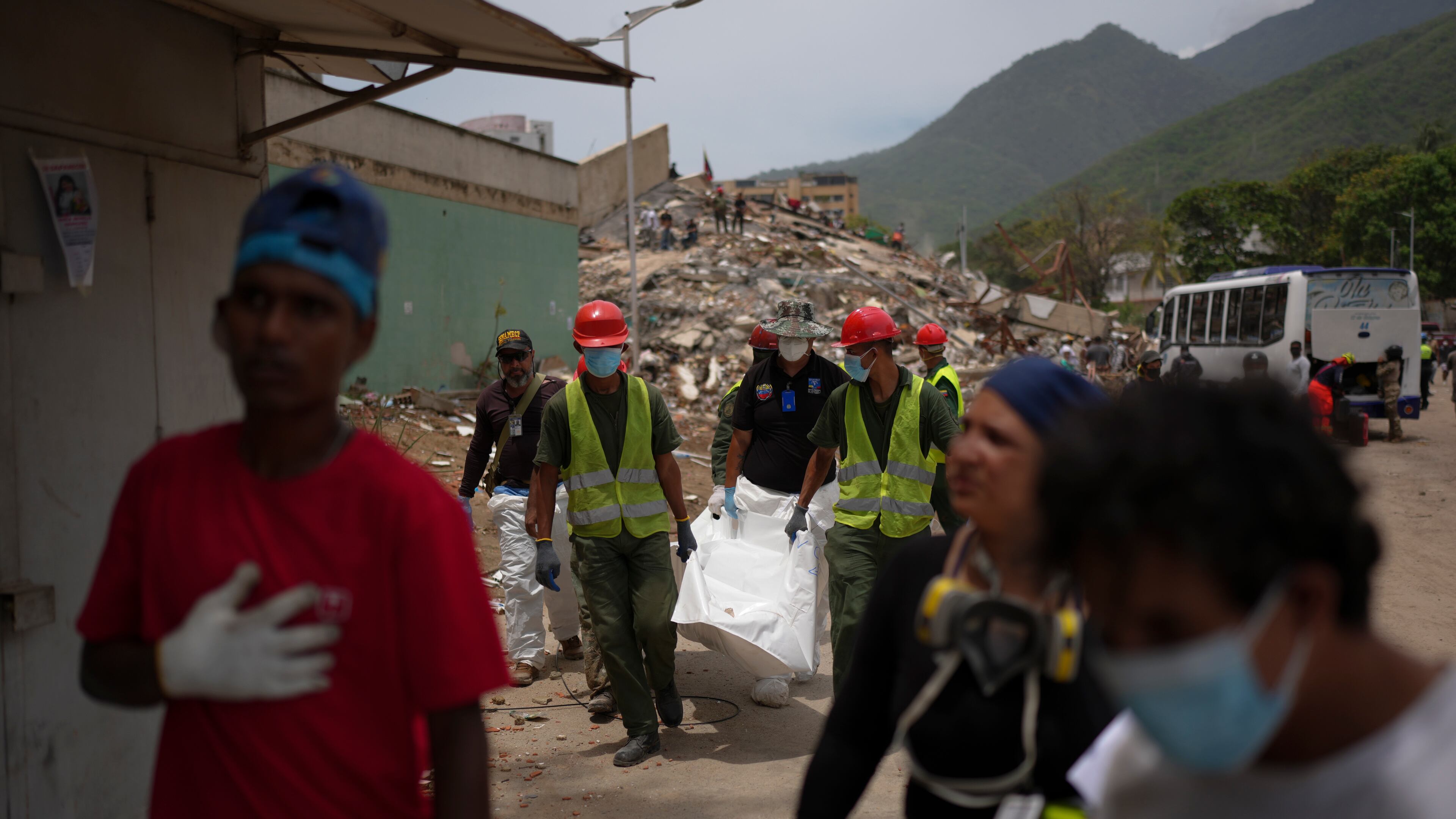 Rescue workers and forensic technician Joel Mirabal, back left, recover the body of an earthquake victim in La Guaira, Venezuela, Tuesday, June 30, 2026. (AP Photo/Matias Delacroix)