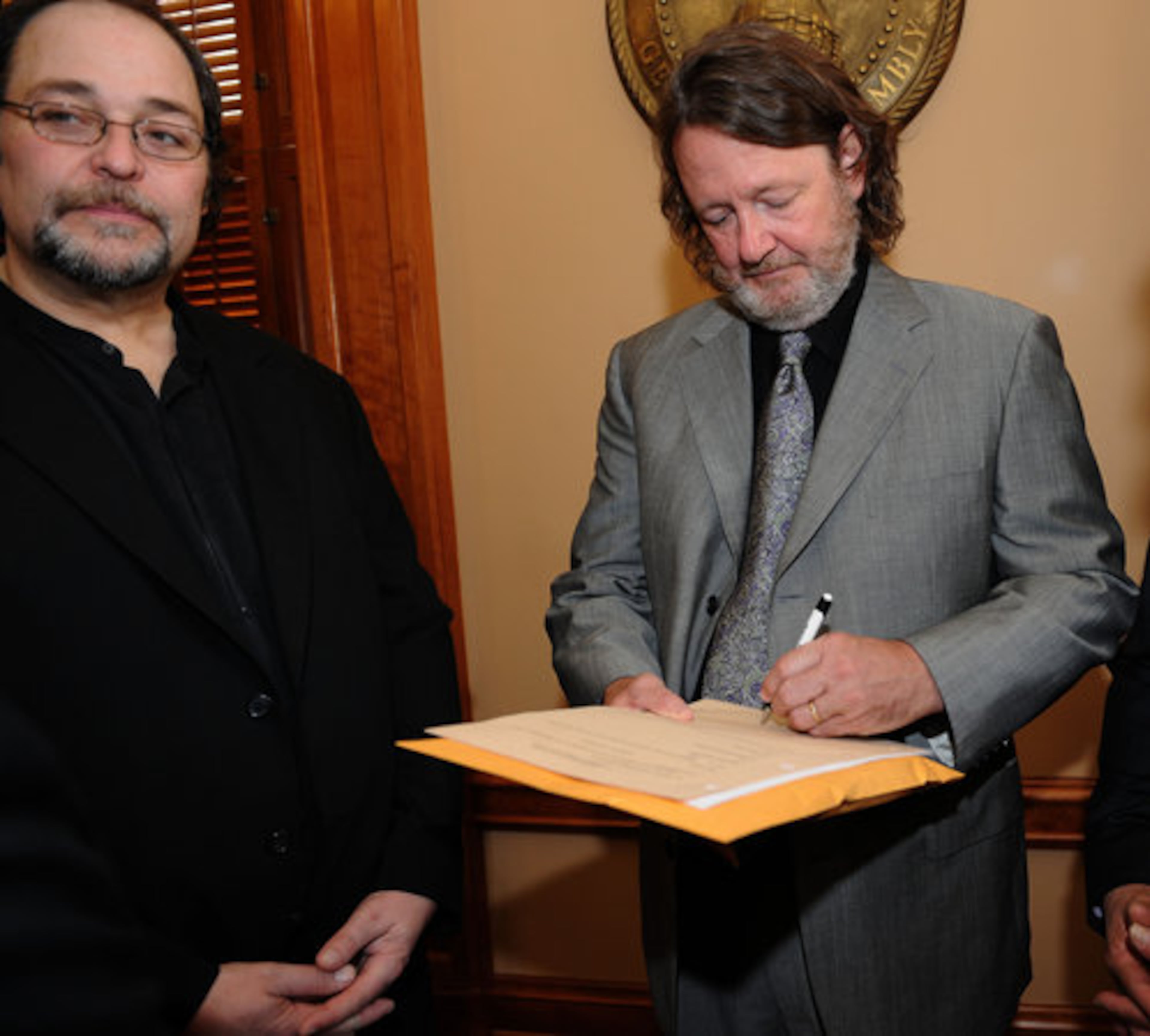 Widespread Panic lead singer John Bell gives an autograph inside the Georgia House of Representatives as band member Todd Nance stands next to him on Tuesday, Feb 15, 2011.