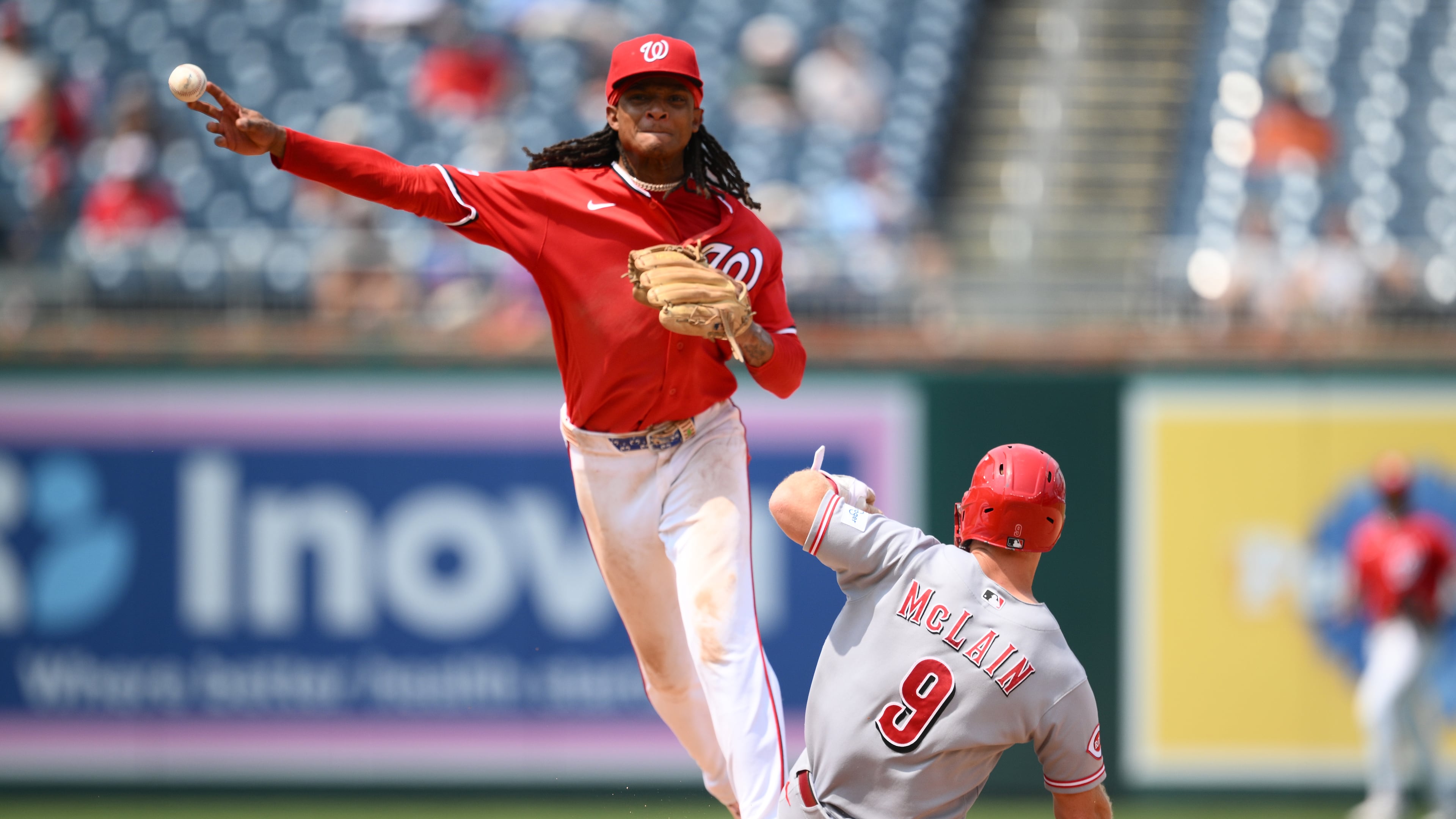 Cincinnati Reds' Matt McLain (9) is out at second base as Washington Nationals shortstop CJ Abrams, top, throws to first base to put out Reds' TJ Friedl for a double play during the eighth inning of a baseball game, Sunday, Aug. 9, 2026, in Washington. (AP Photo/Nick Wass)