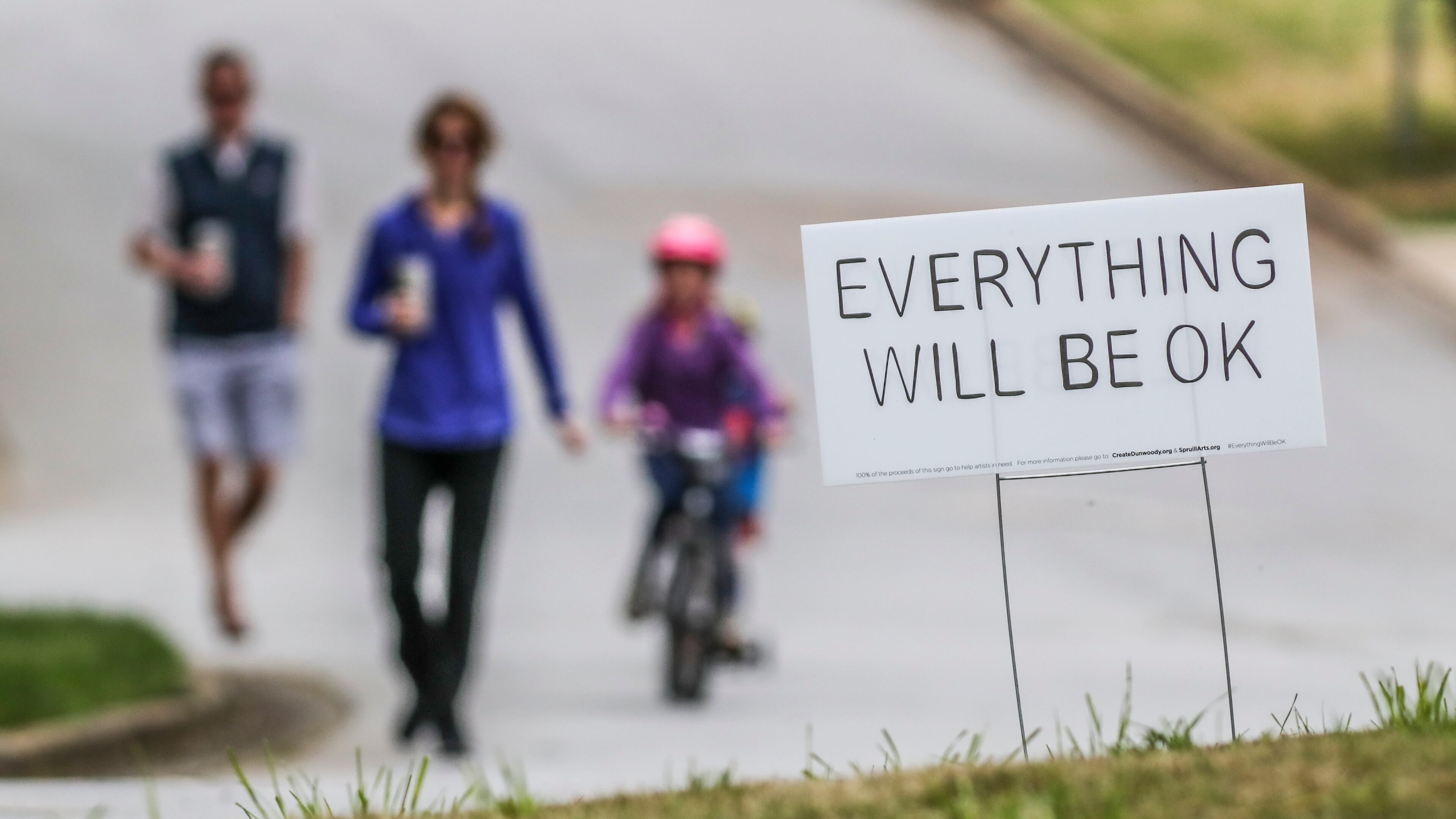 A family passes an "Everything will be OK" yard sign in Dunwoody during the early days of COVID-19 in Georgia. (John Spink / jspink@ajc.com)