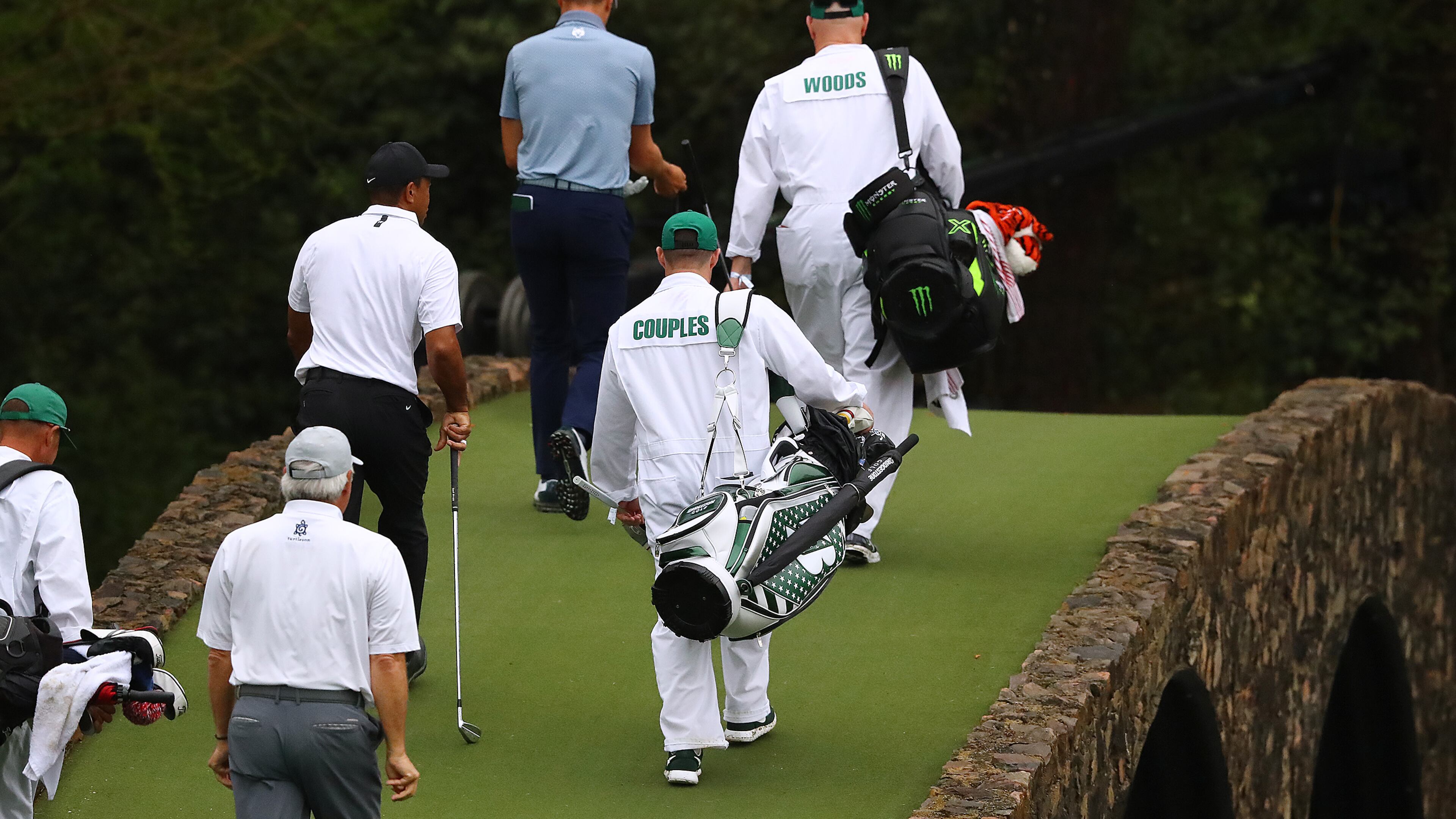 Fred Couples, Tiger Woods and Justin Thomas cross the Ben Hogan Bridge to the 12th green during their practice round for the Masters at Augusta National Golf Club on Wednesday, April 6, 2022, in Augusta, Georgia. (Curtis Compton/The Atlanta Journal-Constitution/TNS)