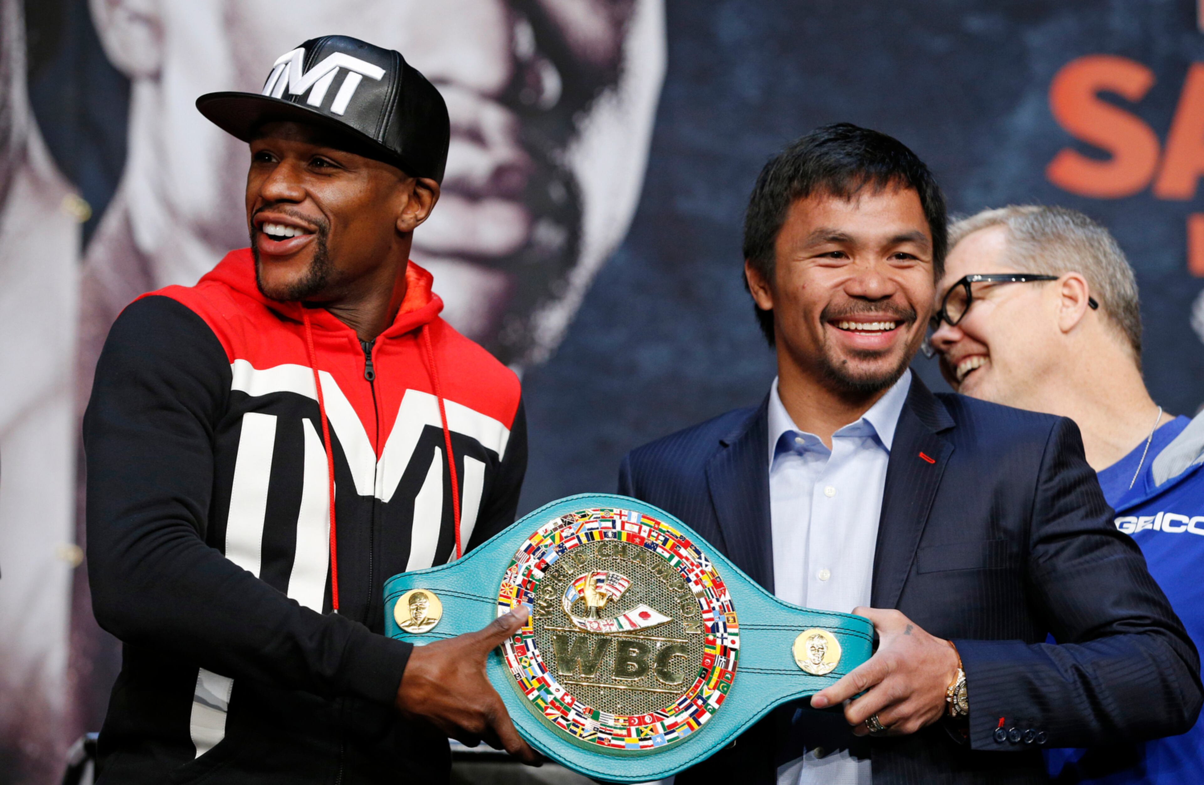 GRABBING THE BELT--Boxers Floyd Mayweather Jr., left, and Manny Pacquiao pose with a WBC belt during a press conference Wednesday, April 29, 2015, in Las Vegas. Mayweather will face Pacquiao in a welterweight title fight in Las Vegas on May 2. (AP Photo/John Locher)